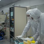 Two people looking at a laptop inside the WNF cleanroom