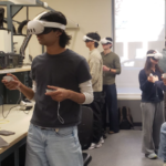Students standing in lab wearing virtual reality headsets and holding controllers in their hands.